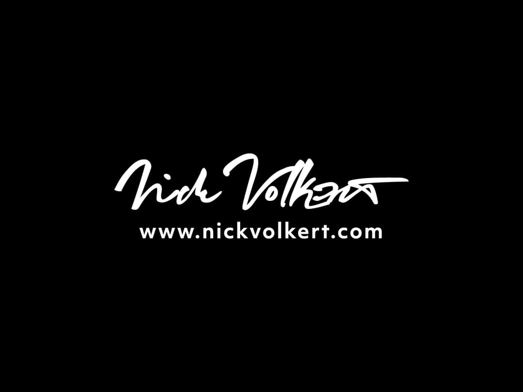 A script logo in white on black for Nick Volkert Dot Com.