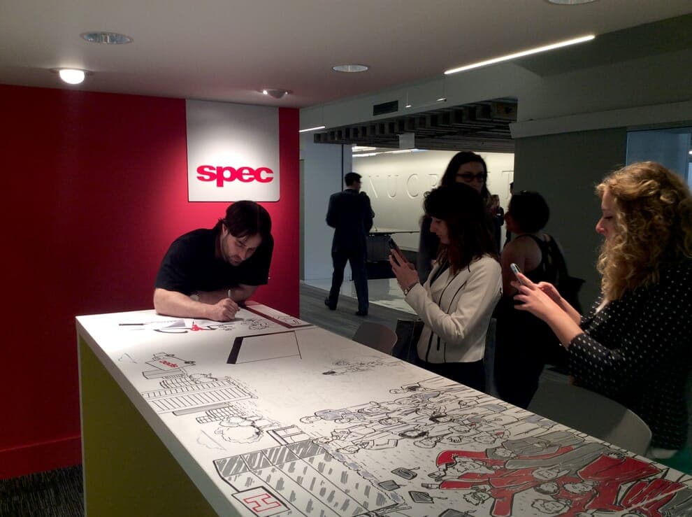 Onlookers viewing Nick Volkert working on mural for Spec Furniture in the Merchandise Mart